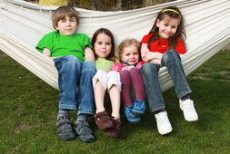 Vier Kinder sitzen zusammen in einer Hängematte | © eyezoom100 - Fotolia